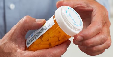 Man holding bottle of pills