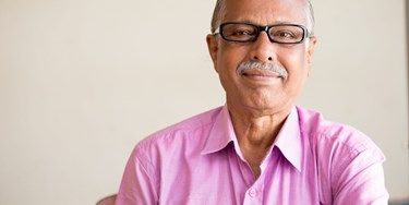 Man smiling wearing a lovely pink shirt