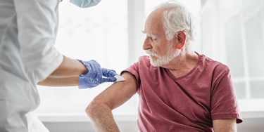 Man receiving vaccine by medical professional