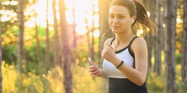Woman jogging through a park at sunrise