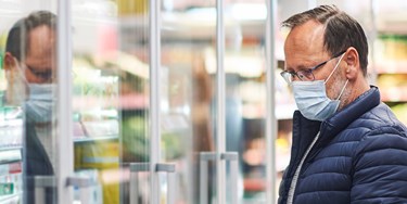 Man wearing mask shopping in supermarket