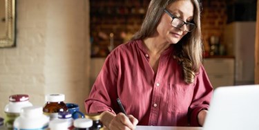 Woman taking notes using a laptop